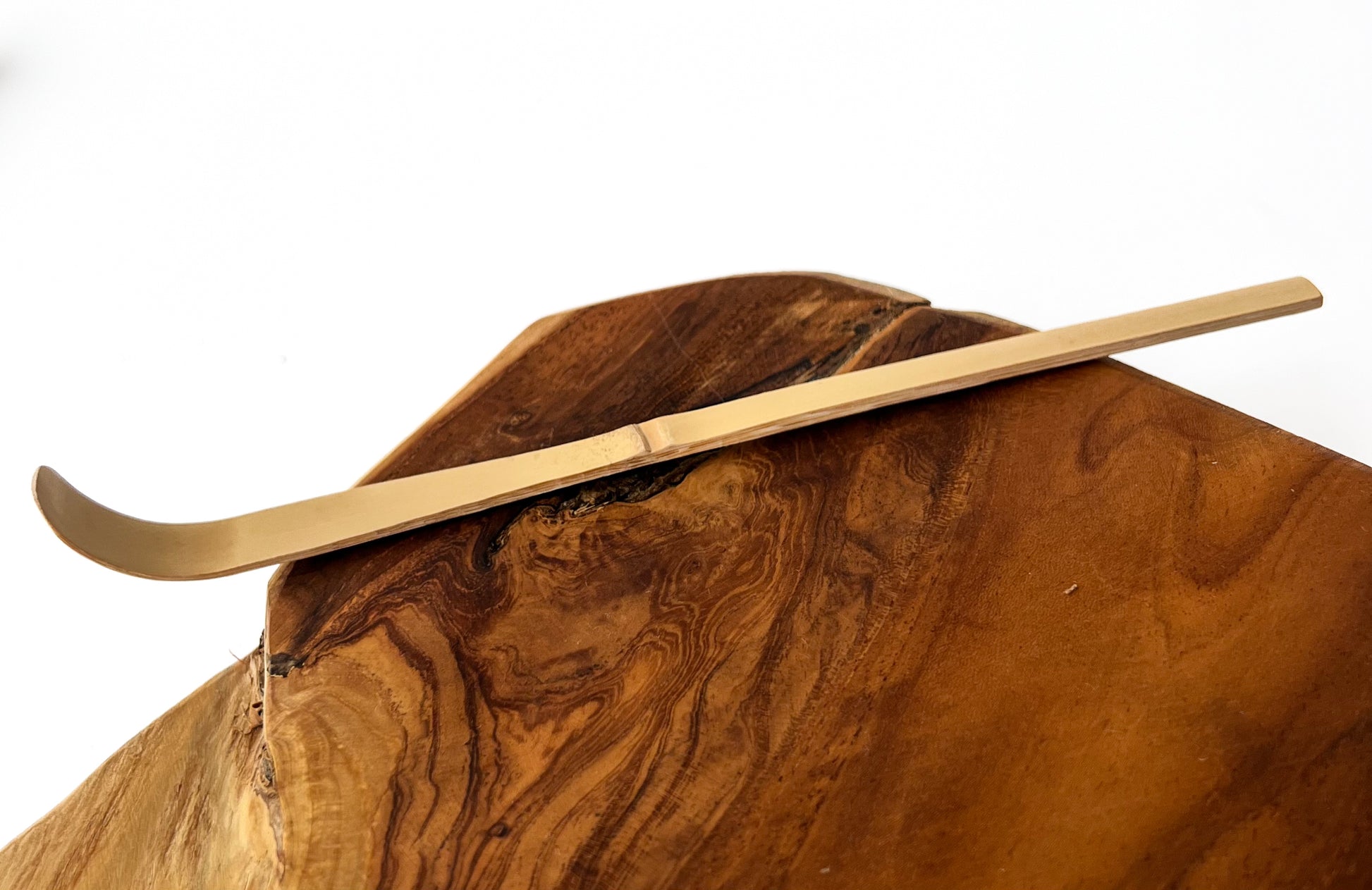 Tradiční japonská bambusová naběračka chashaku z bílého bambusu – nástroj pro přípravu čaje matcha, ručně vyřezávaný s jemně zakřiveným tvarem pro přesné dávkování.